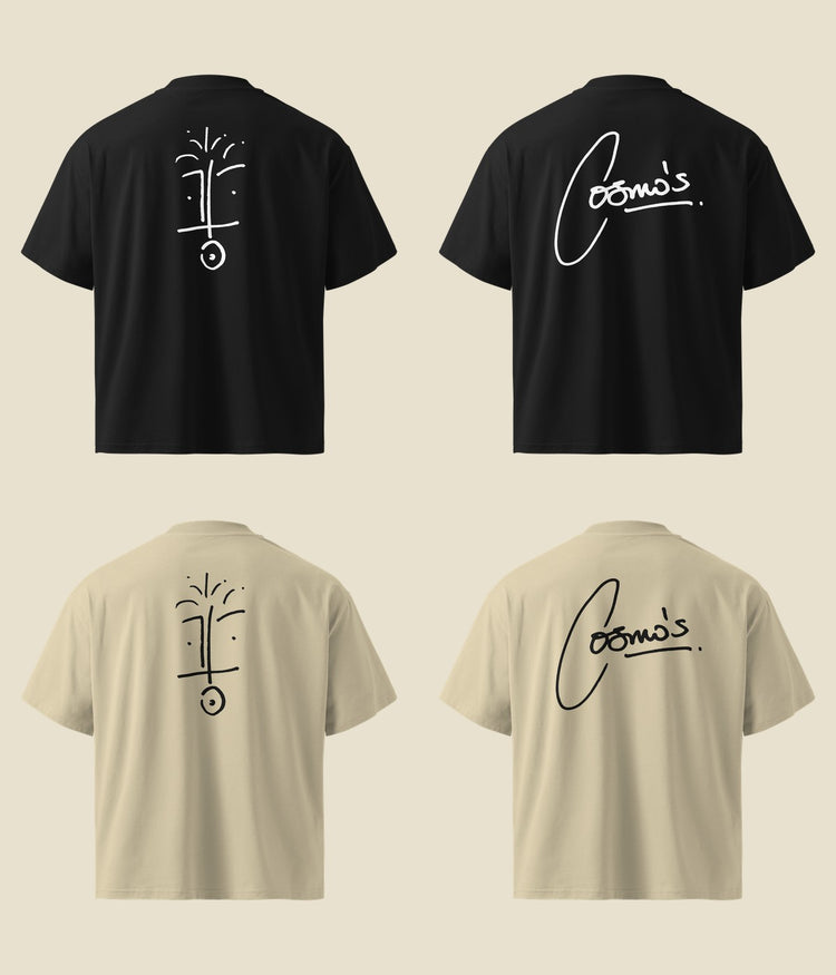the backs of four foundation tees laid flat, black and stone, printed with the face drawing and the cosmo’s signature